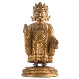 A Sino-Tibetan gilt bronze Buddha, the garment draped in the Gandhara manner, on a lotus shaped