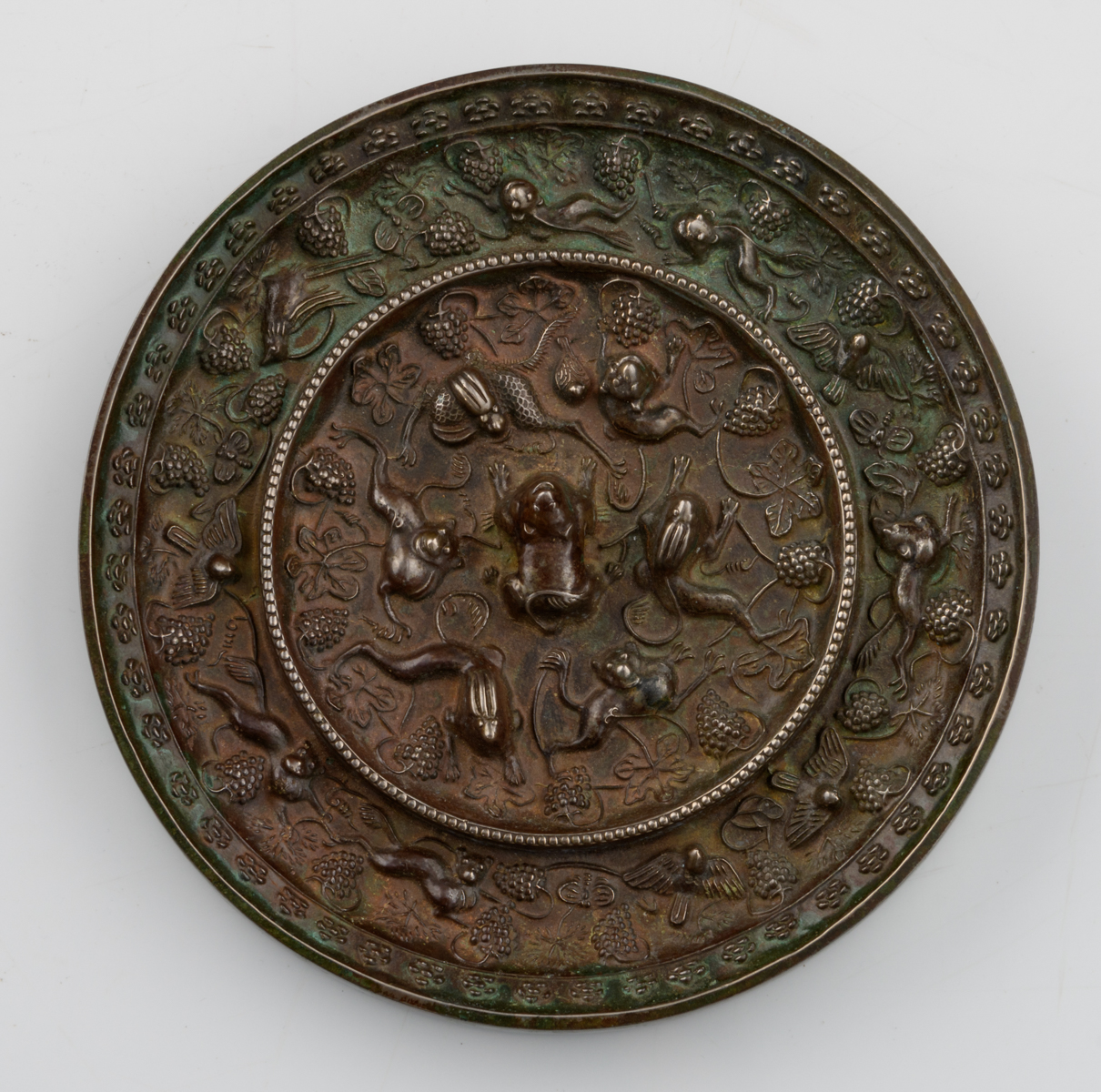 A Chinese silver plated bronze circular mirror, decorated with animals amidst fruiting grapevine, - Image 2 of 3