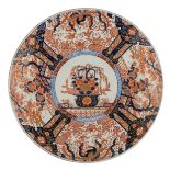 A large Japanese Arita Imari plate, the centre decorated with a flower basket, the roundels with