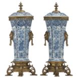 A pair of blue and white floral decorated octagonal shaped Dutch Delftware vases and covers, with