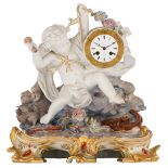 A polychrome decorated biscuit pendule of a putto representing an allegory of music, on a gilt and