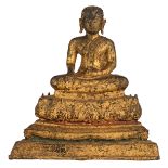 An Oriental gilt bronze seated Varada mudra Buddha on a lotus shaped base, H 22,5 cm