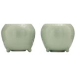 A pair of Chinese celadon glazed tripod cachepots, relief decorated with lotus scrolls, 20thC, H