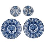 Two large Delftware dishes with a flower basket decoration and a scalloped rim, marked 'De Clauw',