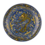 A cobalt blue underglaze and yellow upper glaze emperor plate, decorated with the dragon chasing the