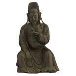 A Chinese Ming style patinated bronze figure of a seated dignitary holding a double gourd bottle,