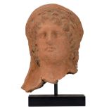 An antique Aphrodite terracotta bust on a noir Belge base, (beginning of the era), H 27,5 (without