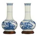 Two Chinese blue and white porcelain bottle vases, decorated with fishes in a mountain lake, on