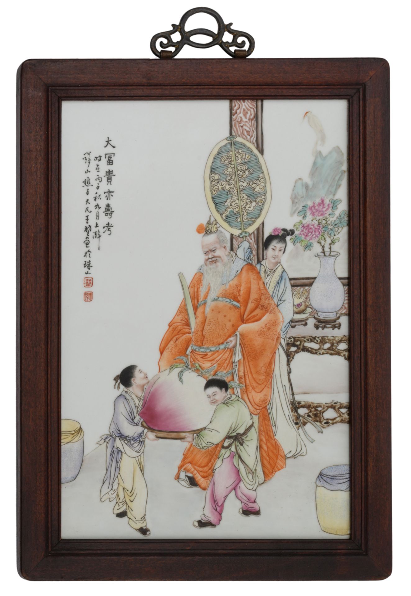 A Chinese polychrome decorated plaque, decorated with two boys presenting a large longevity peach to