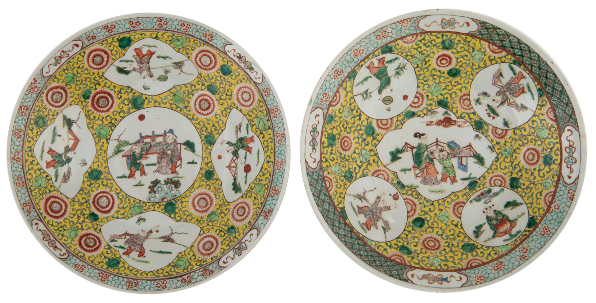 A pair of famille verte chargers, the roundels with playing boys, the central roundel with a scholar