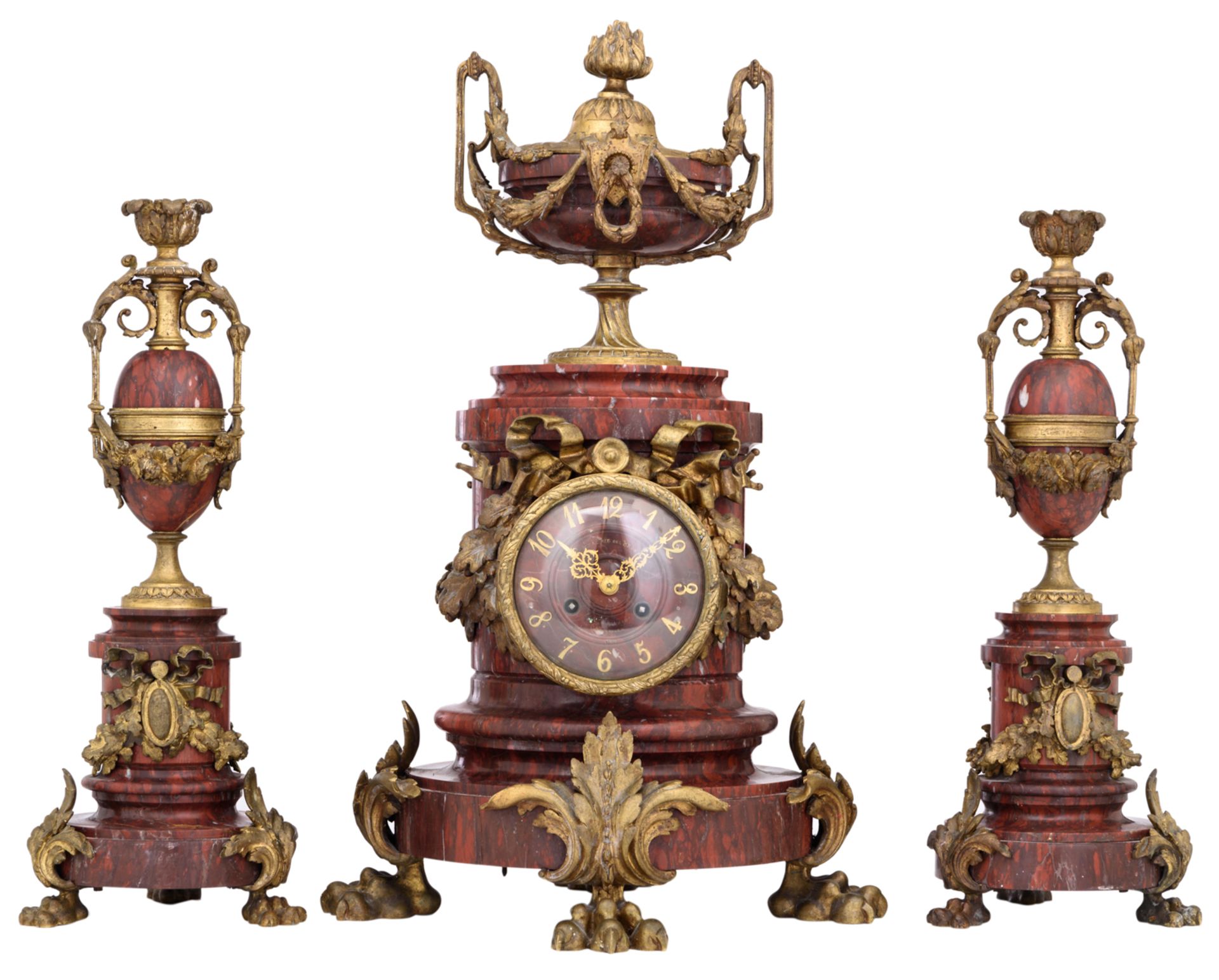 A three-piece rouge Napoleon marble garniture, consisting of a pair of candelabras and a mantel