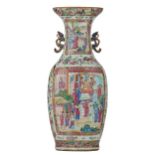 A Chinese Canton famille rose vase with fruits, flowers and butterflies, the roundels decorated with