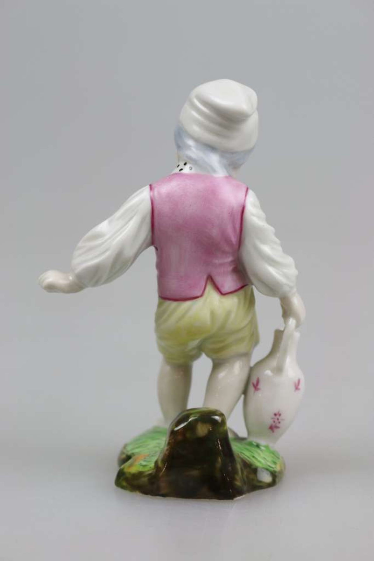 Höchst Porzellanfigur, Junge mit Kanne, farbig staffiert, unterglasurblaue Radmarke, H. 11,5 cm. - Bild 2 aus 3