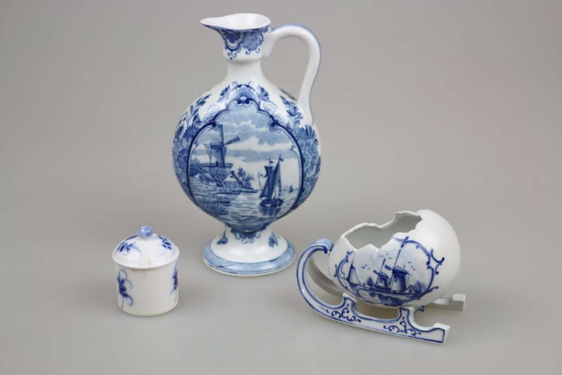 Drei Teile Delft: Henkelvase, H. 22 cm; Schlittenei, L. ca. 13 cm, Deckeltöpfchen H. ca. 7 cm (an