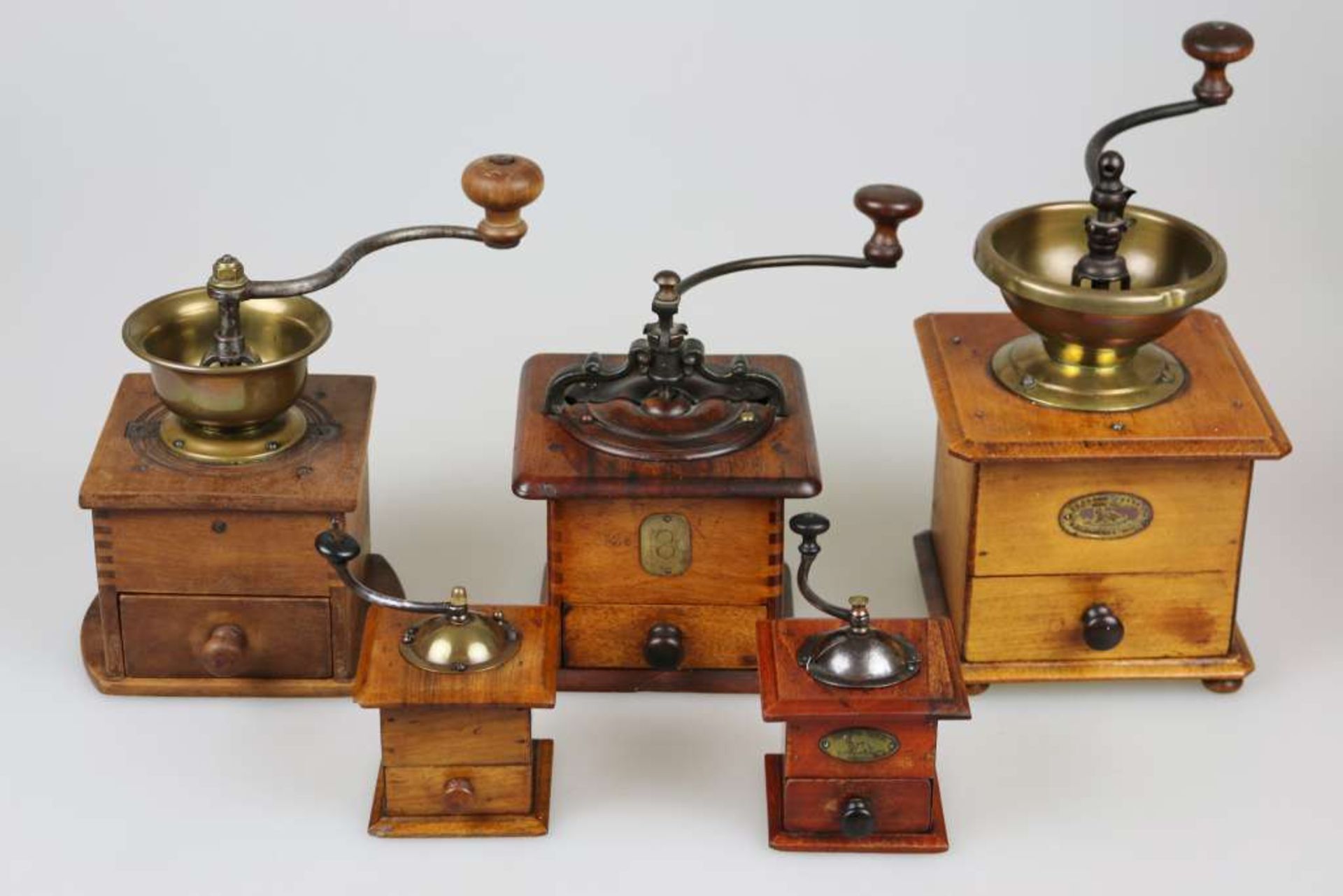 Kaffeemühlen um 1900, Konvolut von fünf Mühlen, verschiedene Größen und Materialien. Höhe: ca. 11,