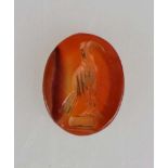 Intaglio, aufrechte Vogeldarstellung, evtl. Adler, auf orangem Karneol, wohl römisch, 1.- 2. Jh.