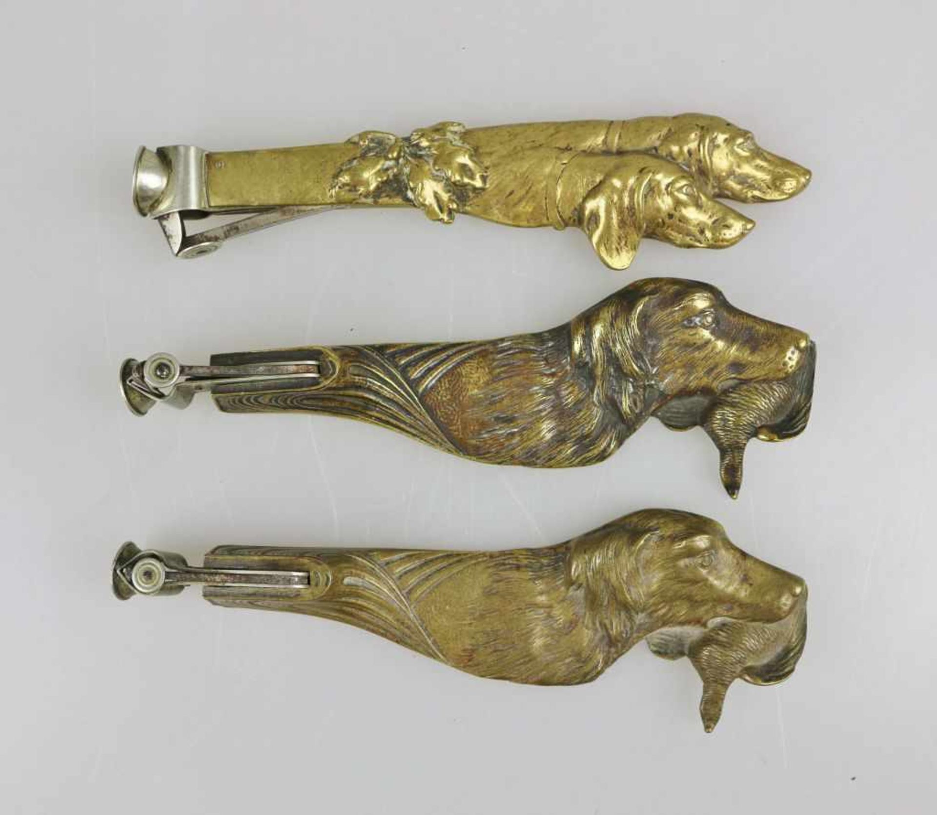 Drei Zigarrenabschneider, Bronzeguss, Griff in der Form eines Setterkopfes bzw. zwei Setterköpfe