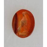 Intaglio, aufrechte Vogeldarstellung, evtl. Adler, auf orangem Karneol, wohl römisch, 1.- 2. Jh.