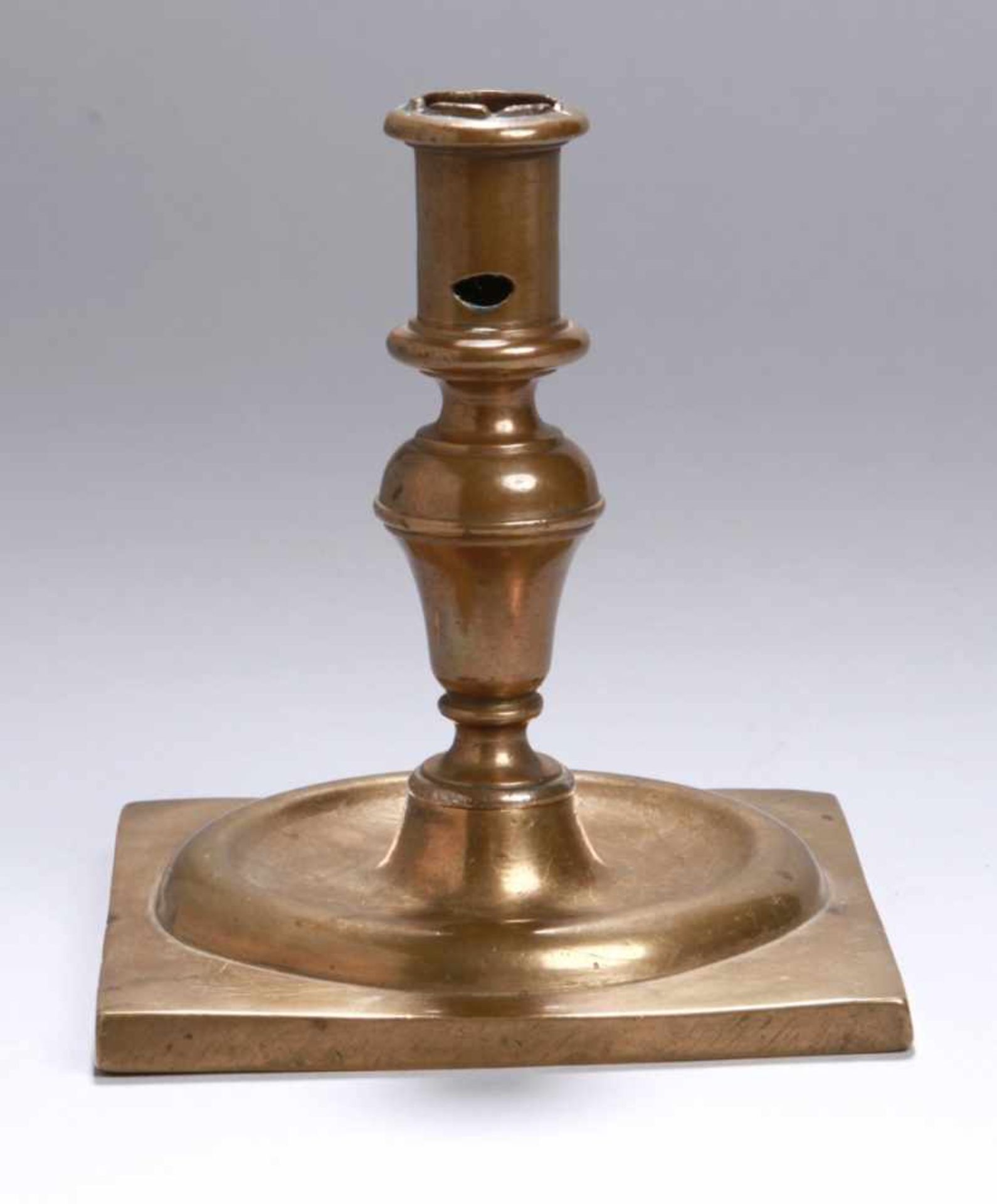 Bronze-Leuchter, 1-flg., 17./18. Jh., quadratische Sockelplatte mit Ringwulst,Balusterschaft und