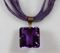 Anhänger, GG 750, 1 rechteckig facettierter Amethyst, an 10-strängigem lilafarbenen Halsband 25.00 %