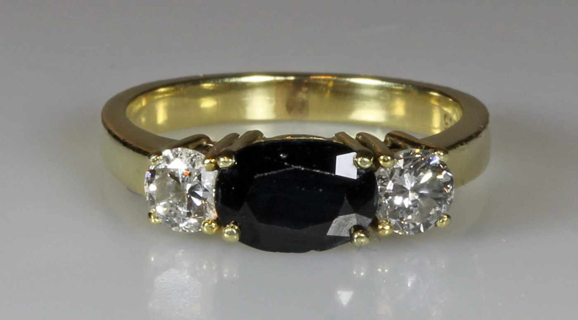 Ring, GG 585, 1 oval facettierter Saphir ca. 1.45 ct., 2 Brillanten zus. ca. 0.79 ct., 4 g, RM 17,5