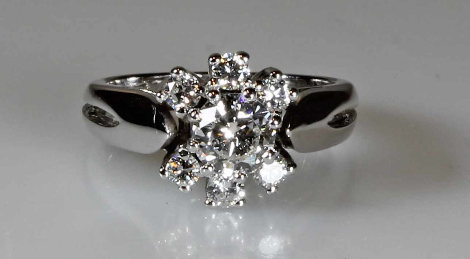 Ring, WG 585, 1 Brillant ca. 0.60 ct., 6 Brillanten zus. ca. 0.30 ct., alle etwa w/vvs,