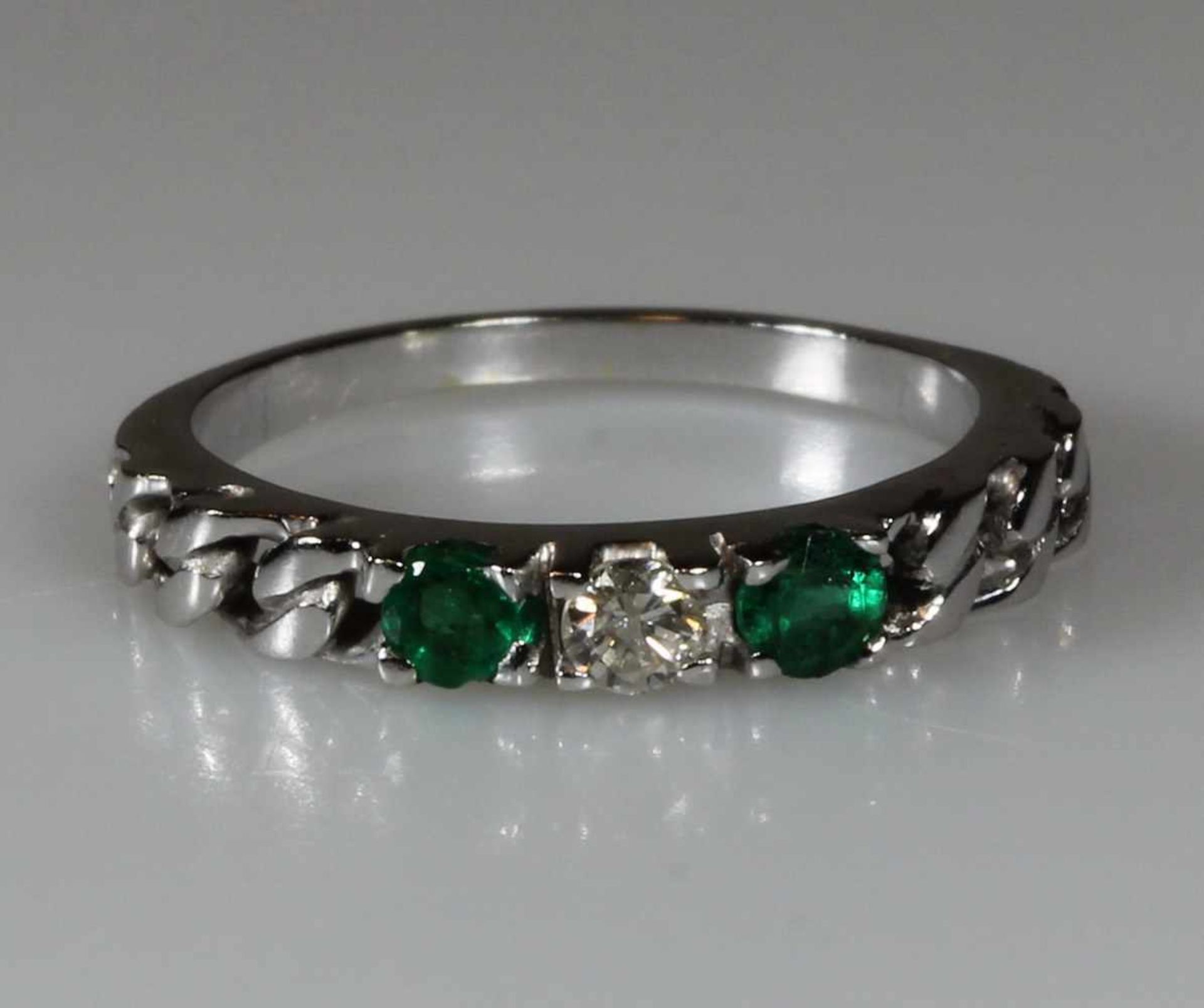 Ring, WG 585, 1 Brillant ca. 0.11 ct., etwa w/p, 2 Smaragde zus. ca. 0.28 ct., 1.5 g, RM 16.5