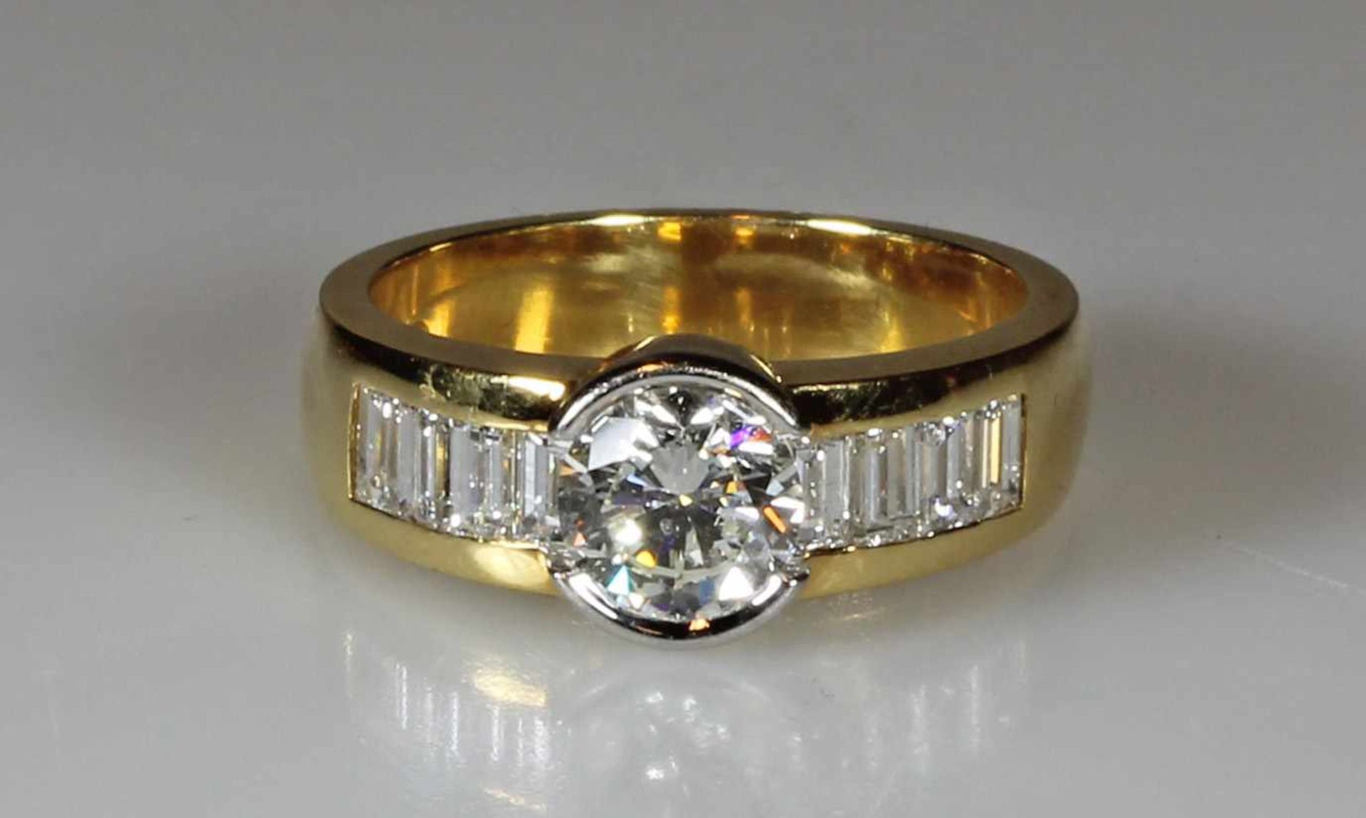 Ring, GG 750, weiß belötet, 1 Brillant ca. 1.0 ct., etwa tcr/si2, 8 Diamant-Baguettes zus. ca. 1.