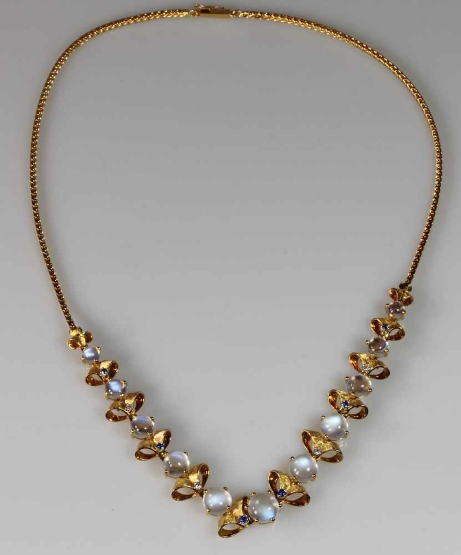 Halskette, GG 750, 11 runde Mondstein-Cabochons ø 4.7 - 8.4 mm, 6 runde facettierte Saphire, 4