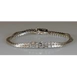 Armband, WG 750, 1 Brillant ca. 0.65 ct., etwa fw/lpr.-vvs, 12 Brillanten zus. ca. 1.15 ct., etwa