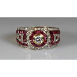 Ring, GG 750, 1 Brillant ca. 0.30 ct., etwa w/si2, 43 Rubincarrées, 62 Achtkant-Diamanten zus. ca.