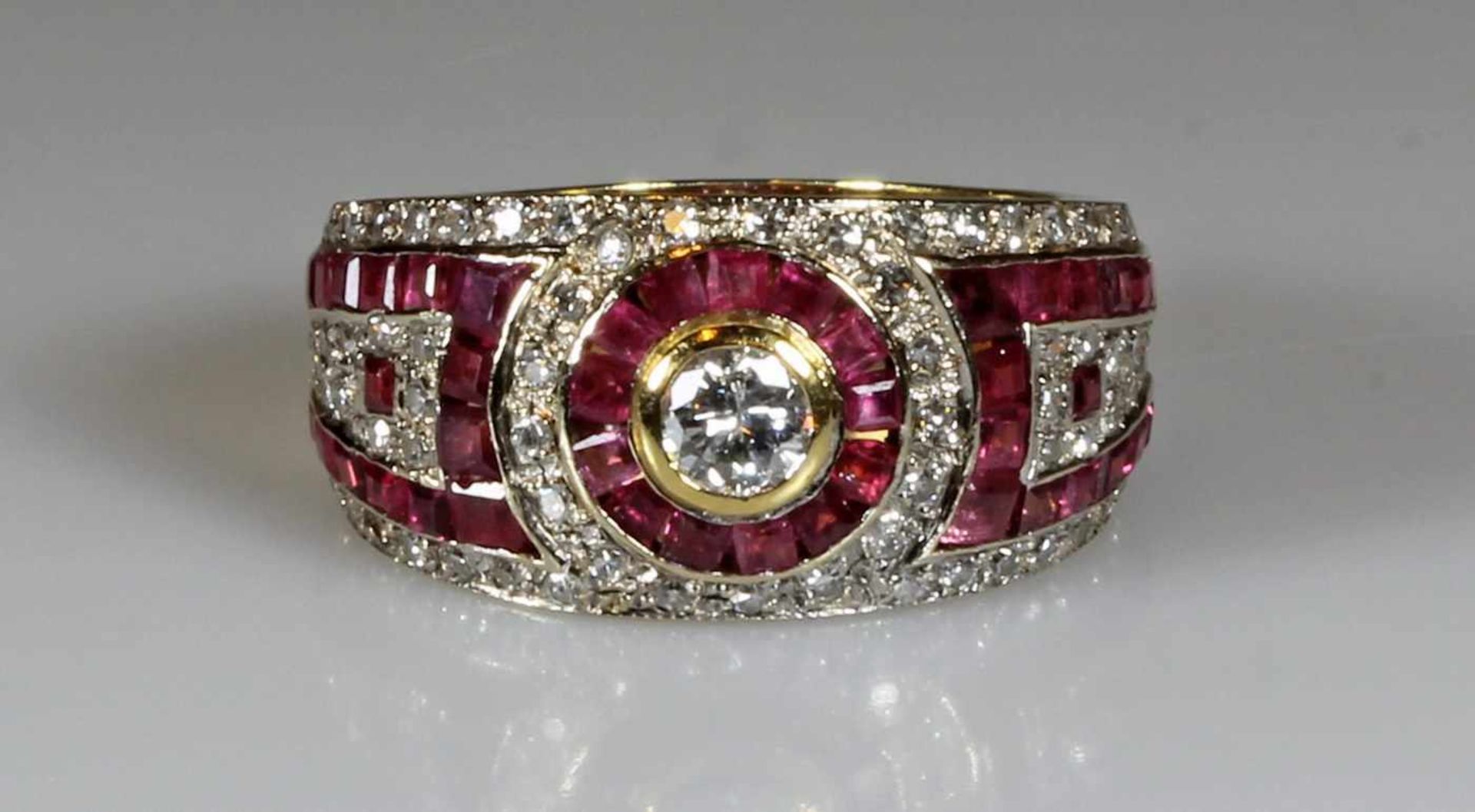 Ring, GG 750, 1 Brillant ca. 0.30 ct., etwa w/si2, 43 Rubincarrées, 62 Achtkant-Diamanten zus. ca.