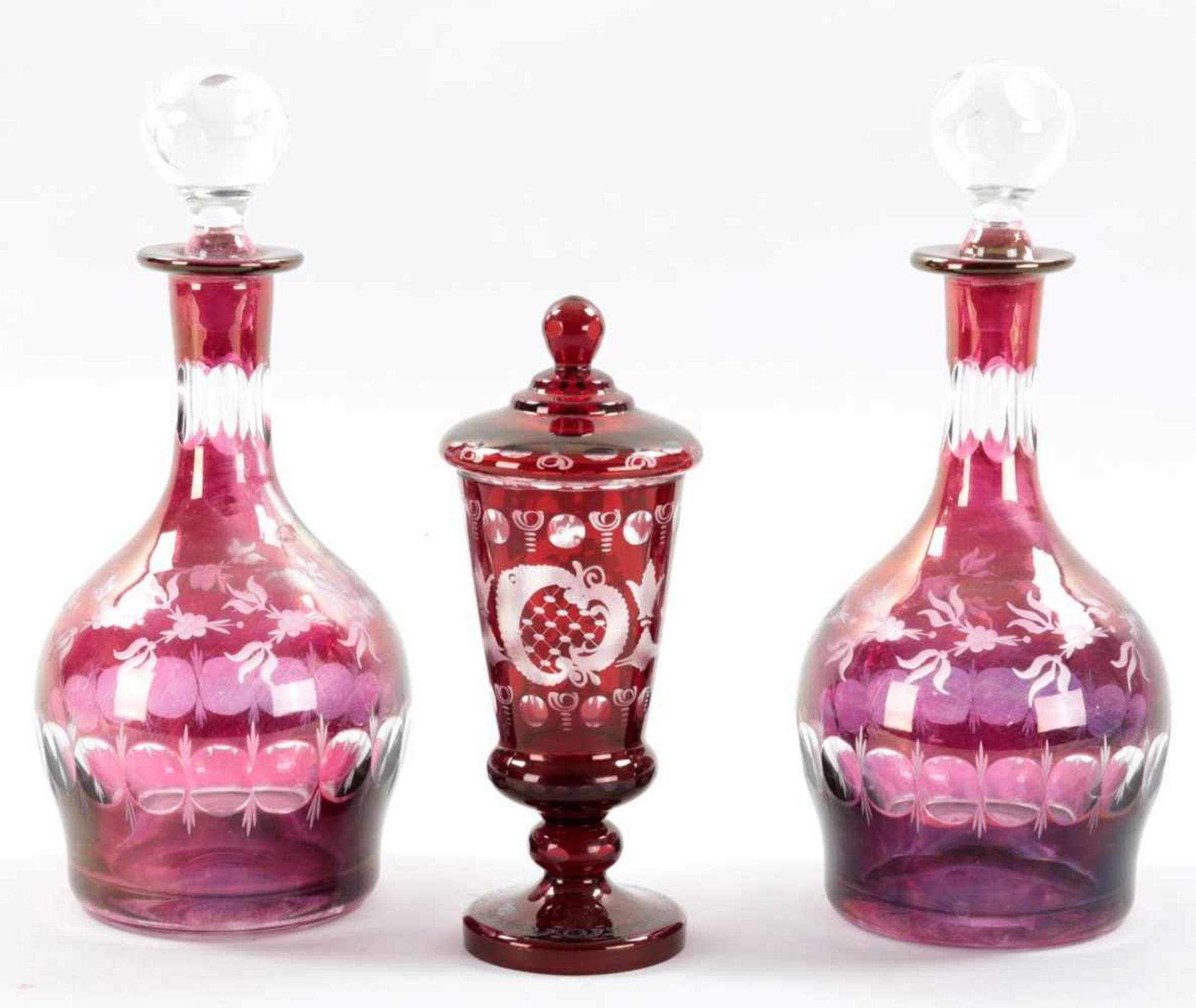 KonvolutGlas, 20.Jh. Das Deckelpokalglas sowie die beiden Karaffen in Rot bzw. Violett überfangen m.