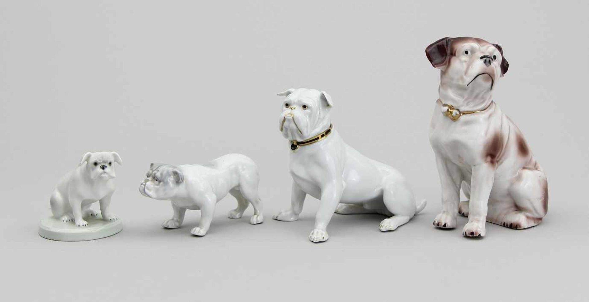 Konvolut von vier Hundefiguren Jeweils Porzellan staffiert und teils leicht vergoldet, a) sitzende