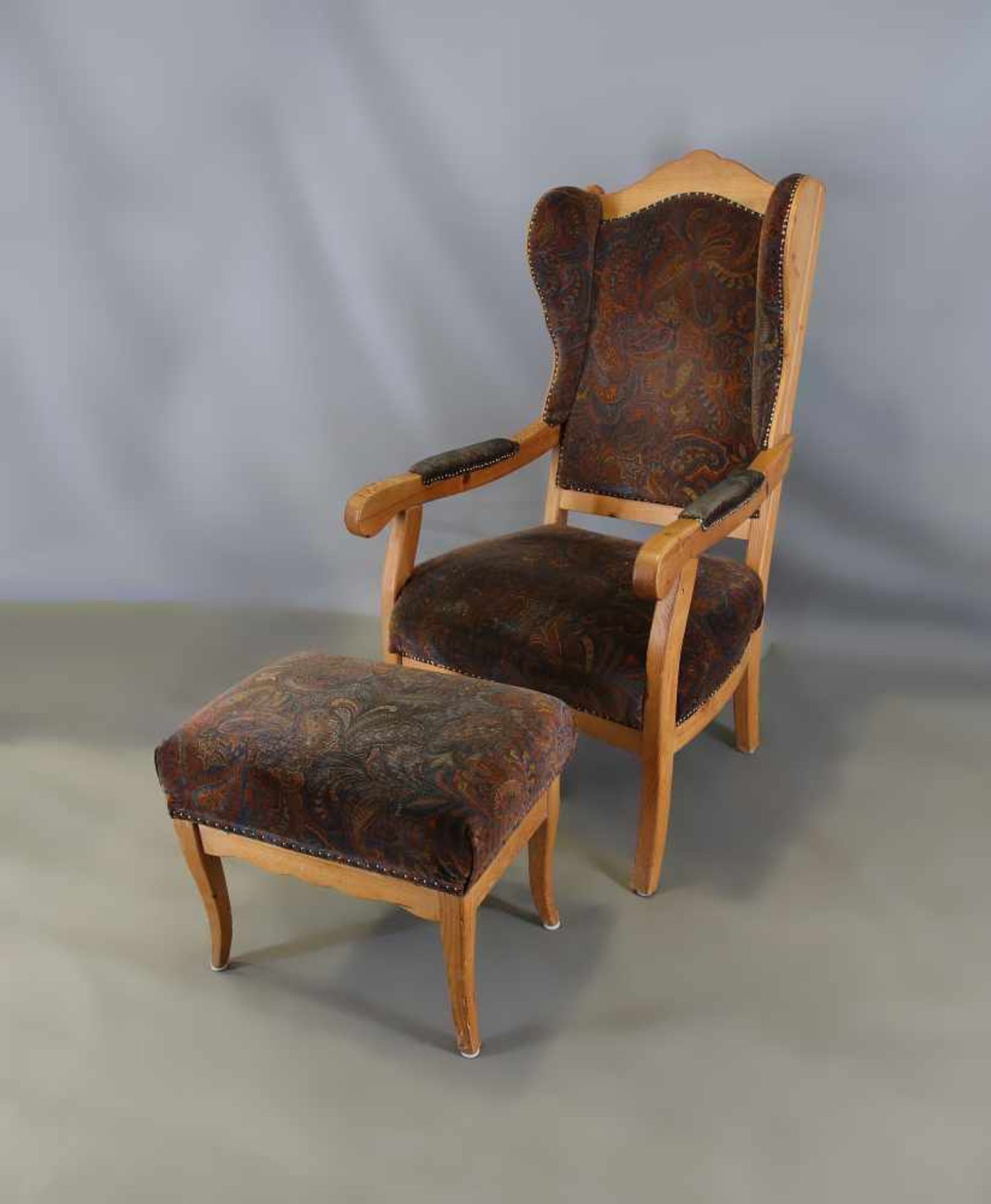 Ohrenbacken-Sessel mit Hocker Nadelholz. 20. Jh., Nadelholz, gepolsterte Rückenlehne und Sitzfläche,