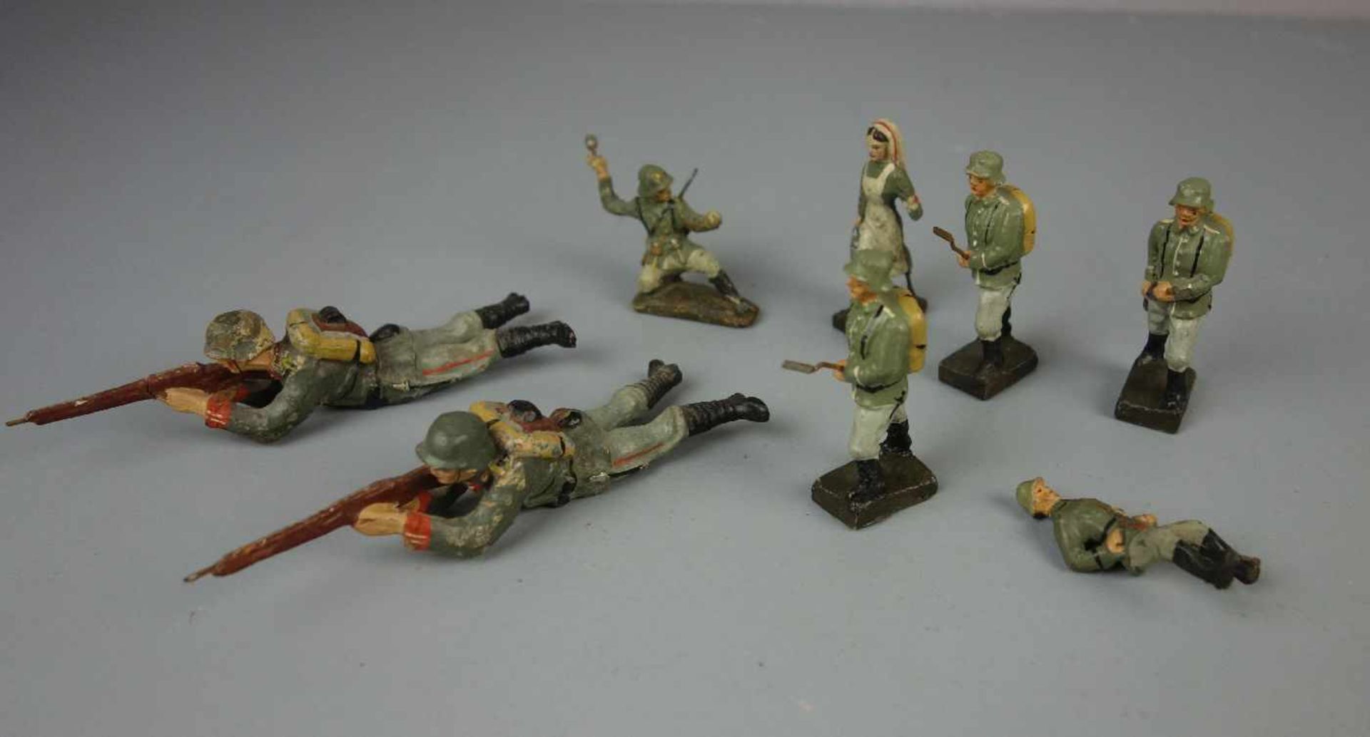 HISTORISCHE SPIELFIGUREN / SPIELZEUG-FIGUREN: Soldaten und Krankenschwester - 8 Stück, 1. H. 20. Jh.