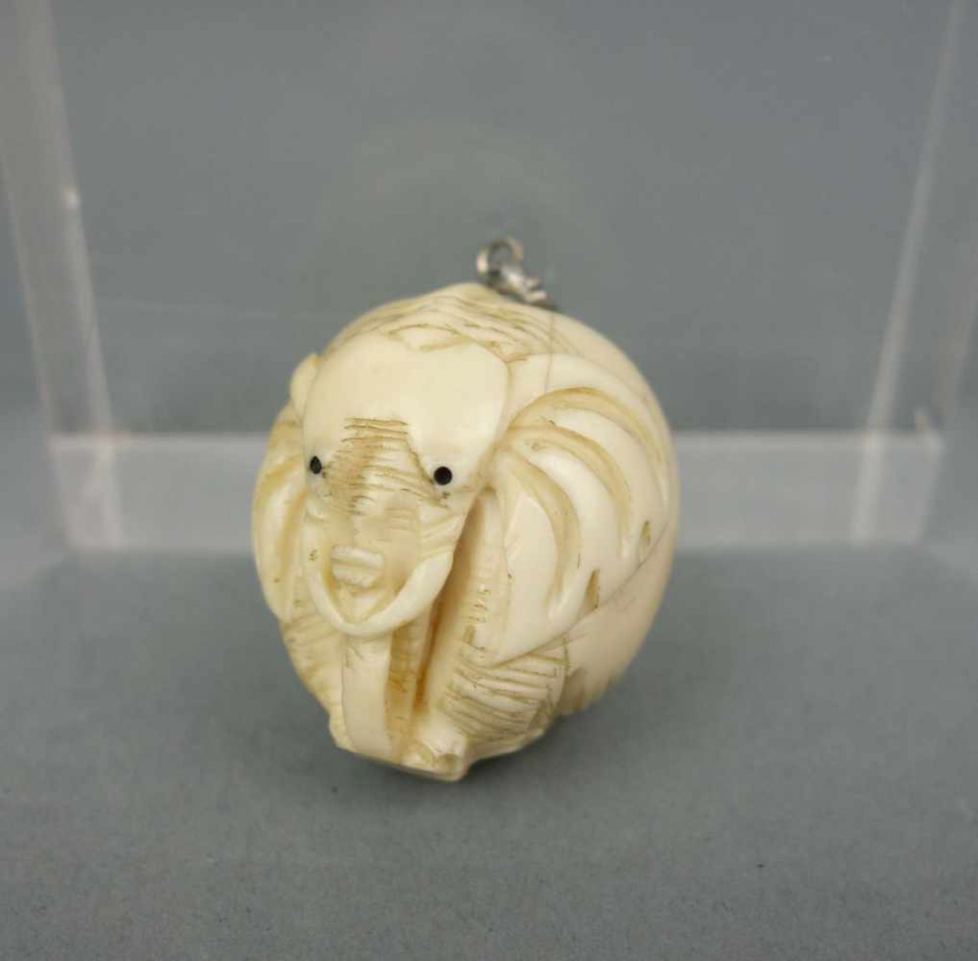 ANHÄNGER "Elefant", Elfenbein, stilisiert, vollplastisch und tropfenförmig geschnitzt. Silberfarbene