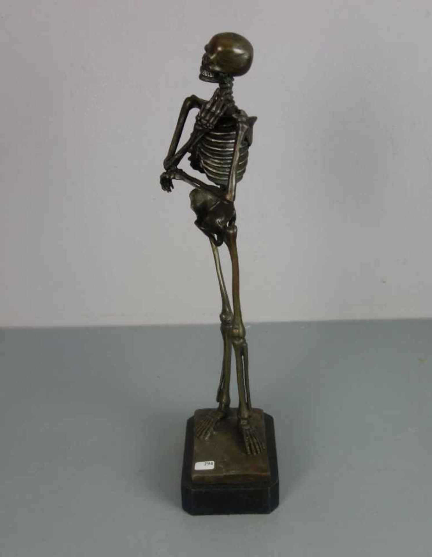 SKULPTUR / sculpture: "Rauchendes Skelett", Bronze, hellbraun patiniert und partiell farbig