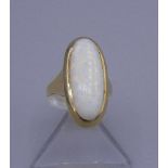 RING mit weißem Opal-Cabochon in 585er Gelbgoldfassung (5,6 g), Ringkopfmaße 2,5 x 1,3 cm. Ring-