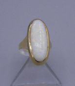 RING mit weißem Opal-Cabochon in 585er Gelbgoldfassung (5,6 g), Ringkopfmaße 2,5 x 1,3 cm. Ring-