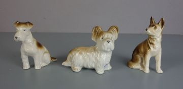 DREI PORZELLANFIGUREN "HUNDE" / porcelain dogs, Porzellan, 20 Jh.. 1) Sitzender Schäferhund,