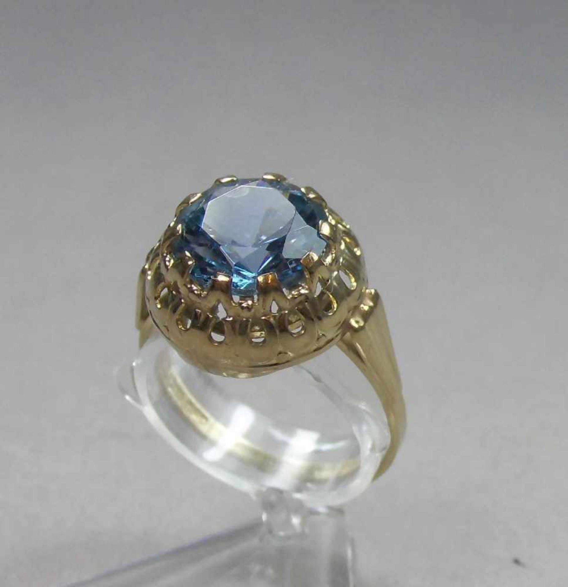 RING, 333er Gelbgold (3,1 g), mittig besetzt mit großem hellblauem Edelstein. Ringschiene gemarkt "