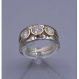 MODERNER RING, besetzt mit 3 Brillanten von 0,5 ct. und zweimal 0,25 ct. in 750er Weissgoldfassung