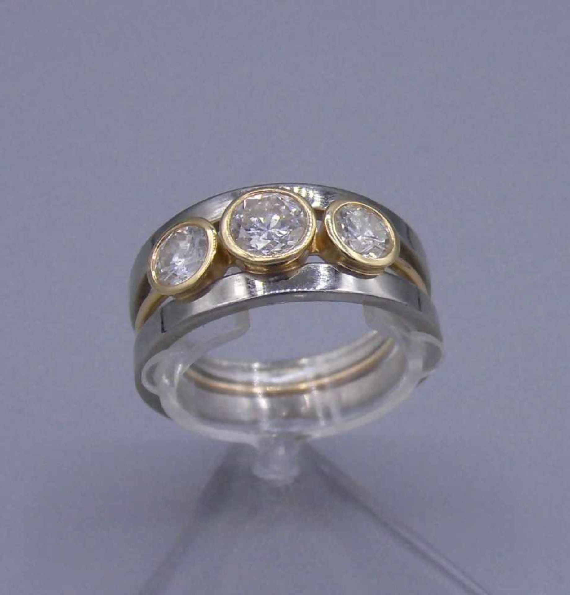 MODERNER RING, besetzt mit 3 Brillanten von 0,5 ct. und zweimal 0,25 ct. in 750er Weissgoldfassung