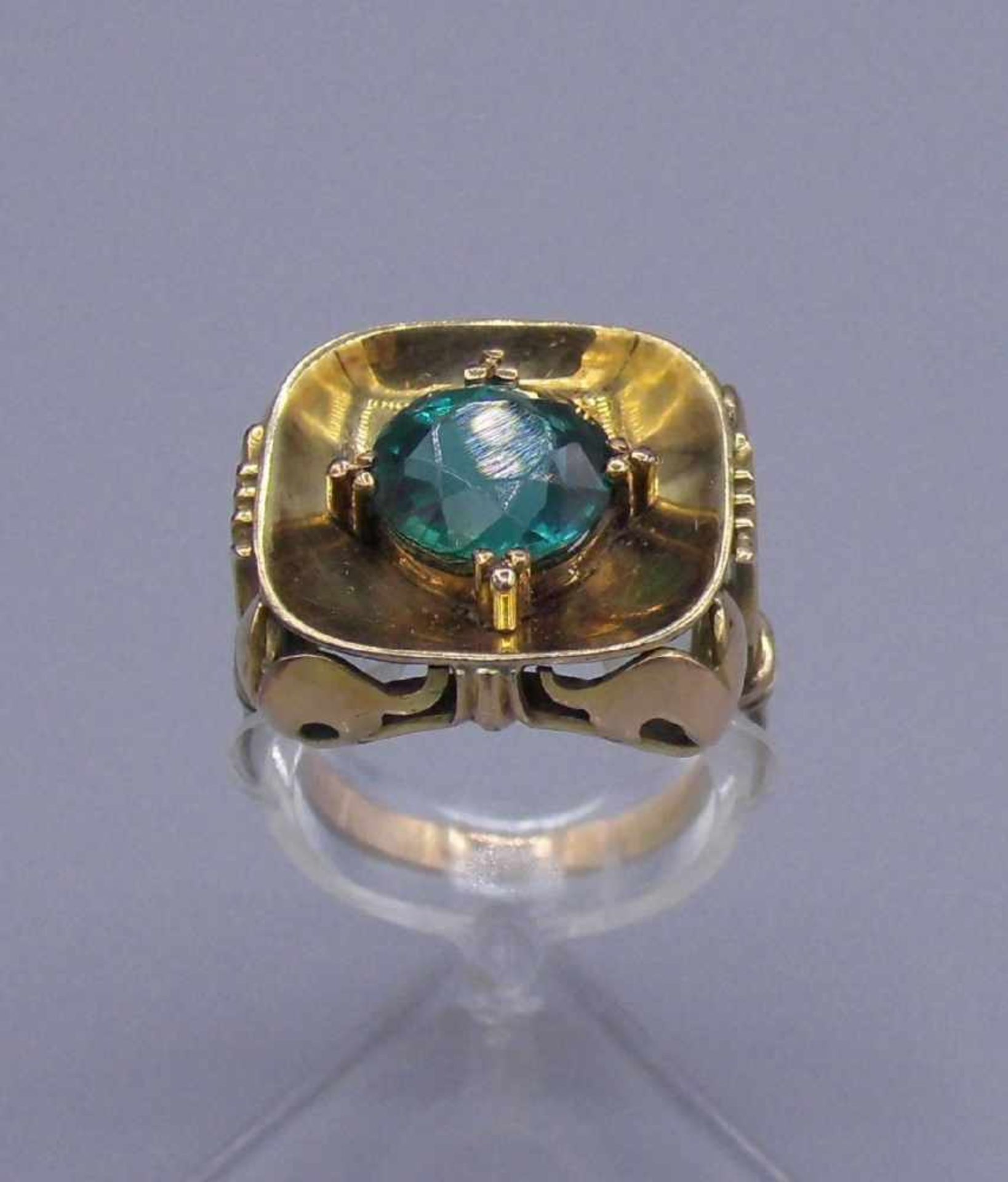 RING mit leuchtend grünem Edelstein in Karreefassung aus 585er Gelbgold (6,2 g). Ringkopfmaße: 1,7 x