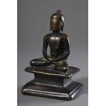 Kleiner Bronze "Buddha" auf schlichtem Sockel, Kopf von kleinem Rubin bekrönt, im Sockel großer