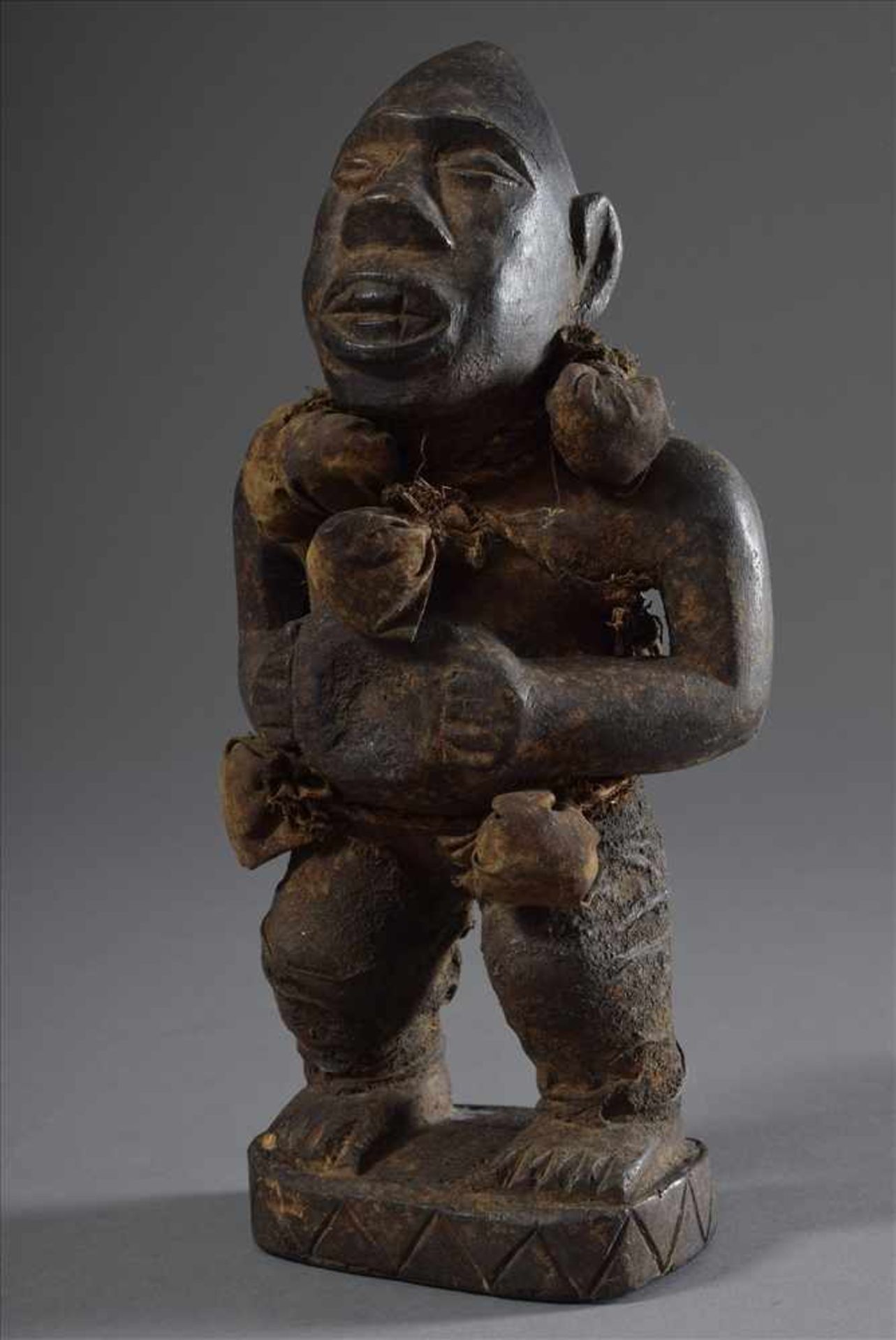 Westafrikanische Fetischfigur mit Reliquiarsäckchen, dunkel gefärbtes Holt, H. 27,5cm, Ø 10cmWest