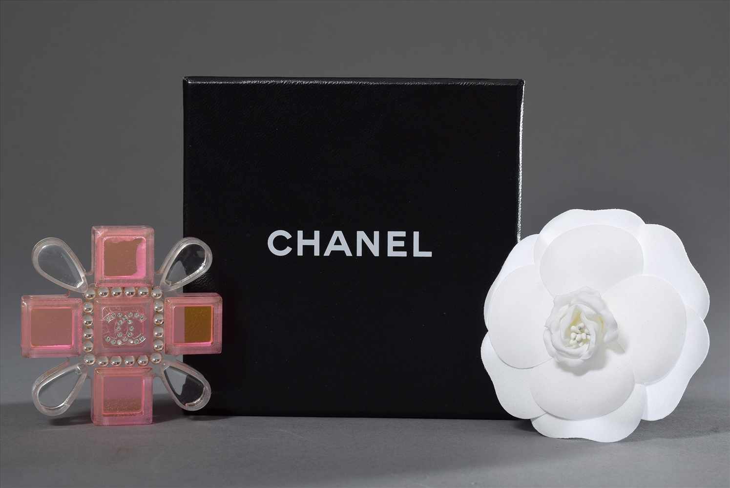 2 Diverse CHANEL Nadeln: weiße Camelie in Original Karton (Ø 8cm) und Acryl "Orden" in neonpink/weiß