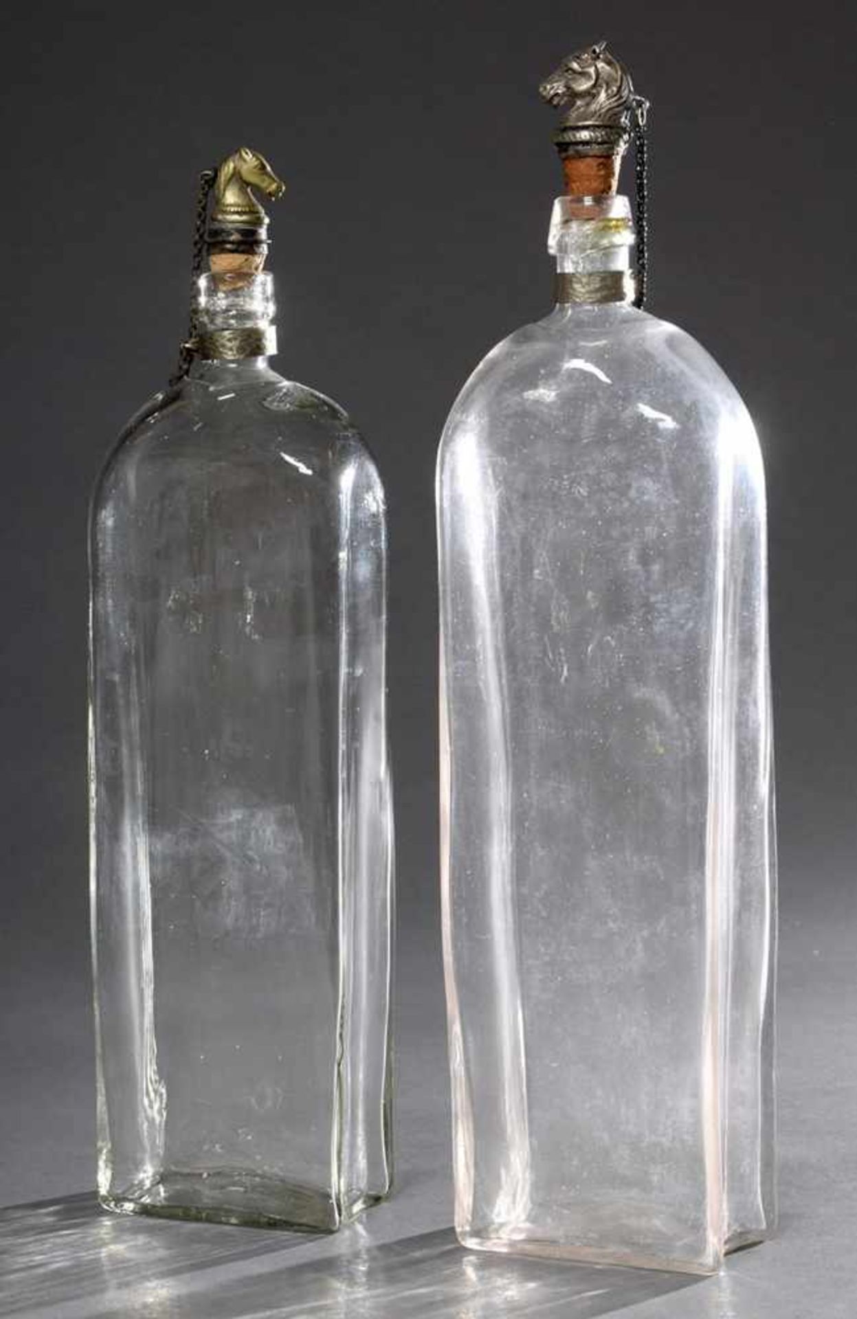 2 Alte eckige Flaschen, in die Form geblasen mit "Pferdekopf" Stöpseln (1x ergänzt), H. 32/34cm,