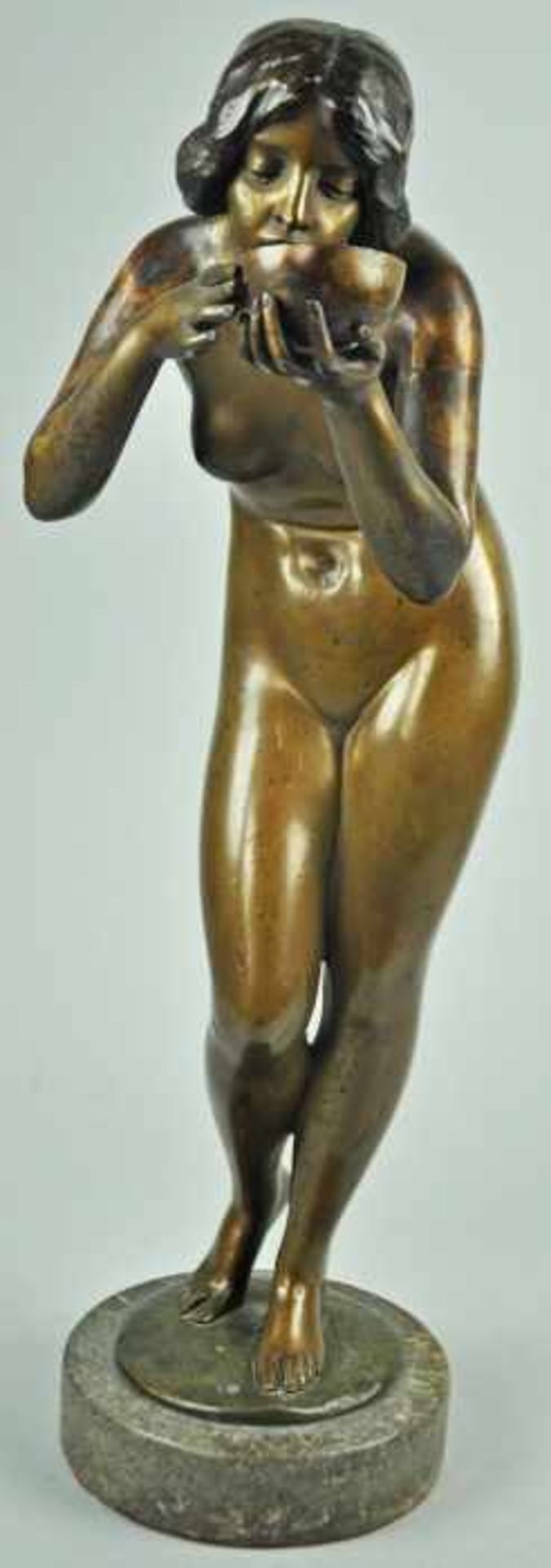 BRONZESKULPTUR "Die Trinkende", braun patinierte Bronzestatue auf rundem Marmorsockel, schwarze